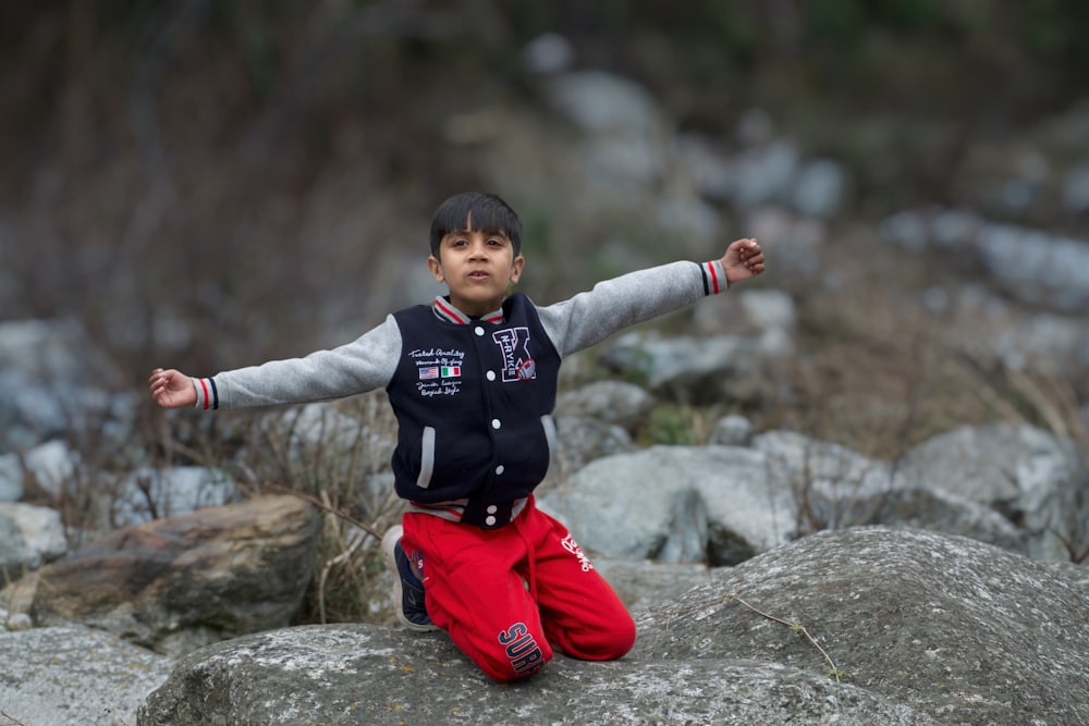 a boy jumping on rocks