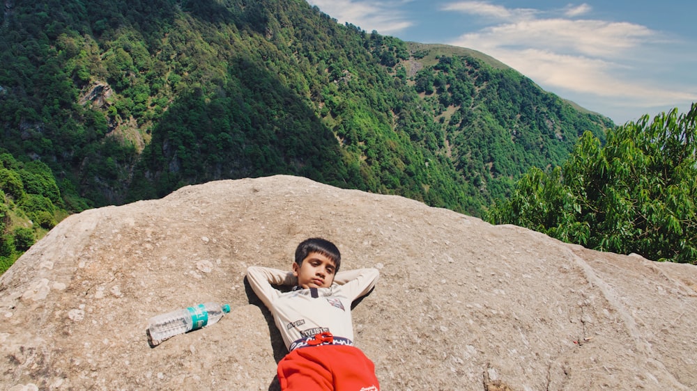 a boy lying on a rock