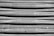 The image displays a close-up view of a corrugated metal surface with a slightly weathered and scratched appearance. There are a few bolts and fixtures visible along the bottom of the metal sheets.