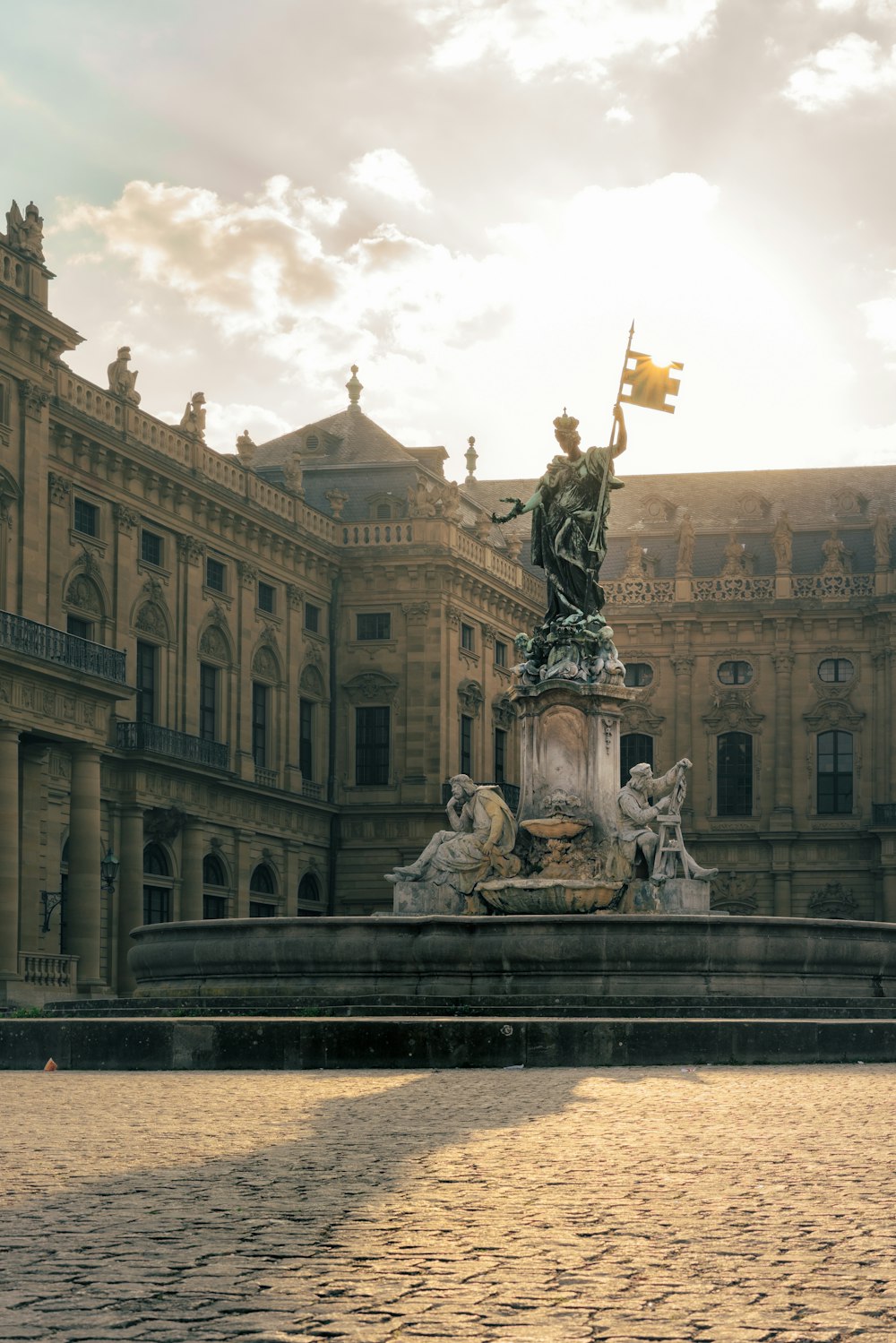 a fountain with statues in front of a building