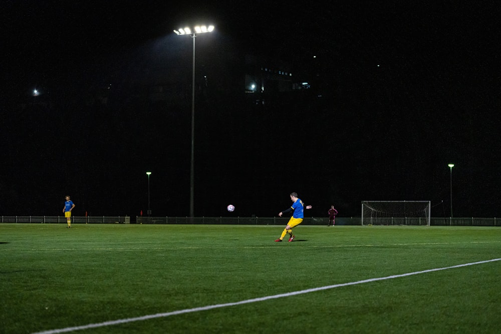 a person in a blue shirt playing football at night