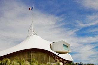 Photo of a modern prefecture building with French flags.
