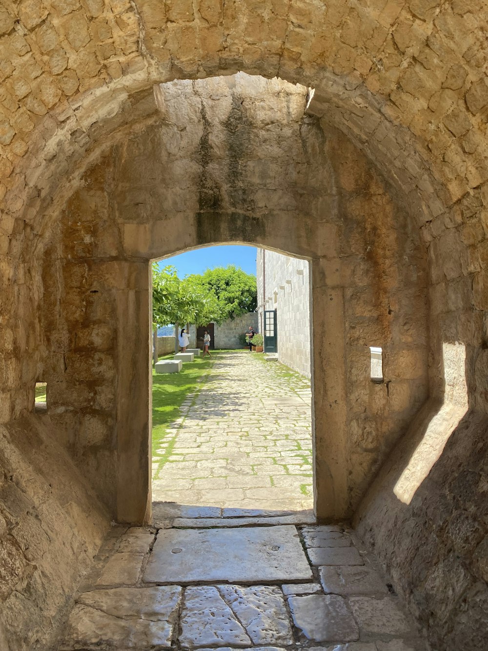 a stone walkway with a stone archway