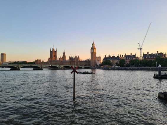a body of water with a bridge and buildings in the background