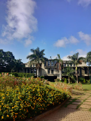 Exterior view of APS Unipod building with lush greenery and clear blue sky.