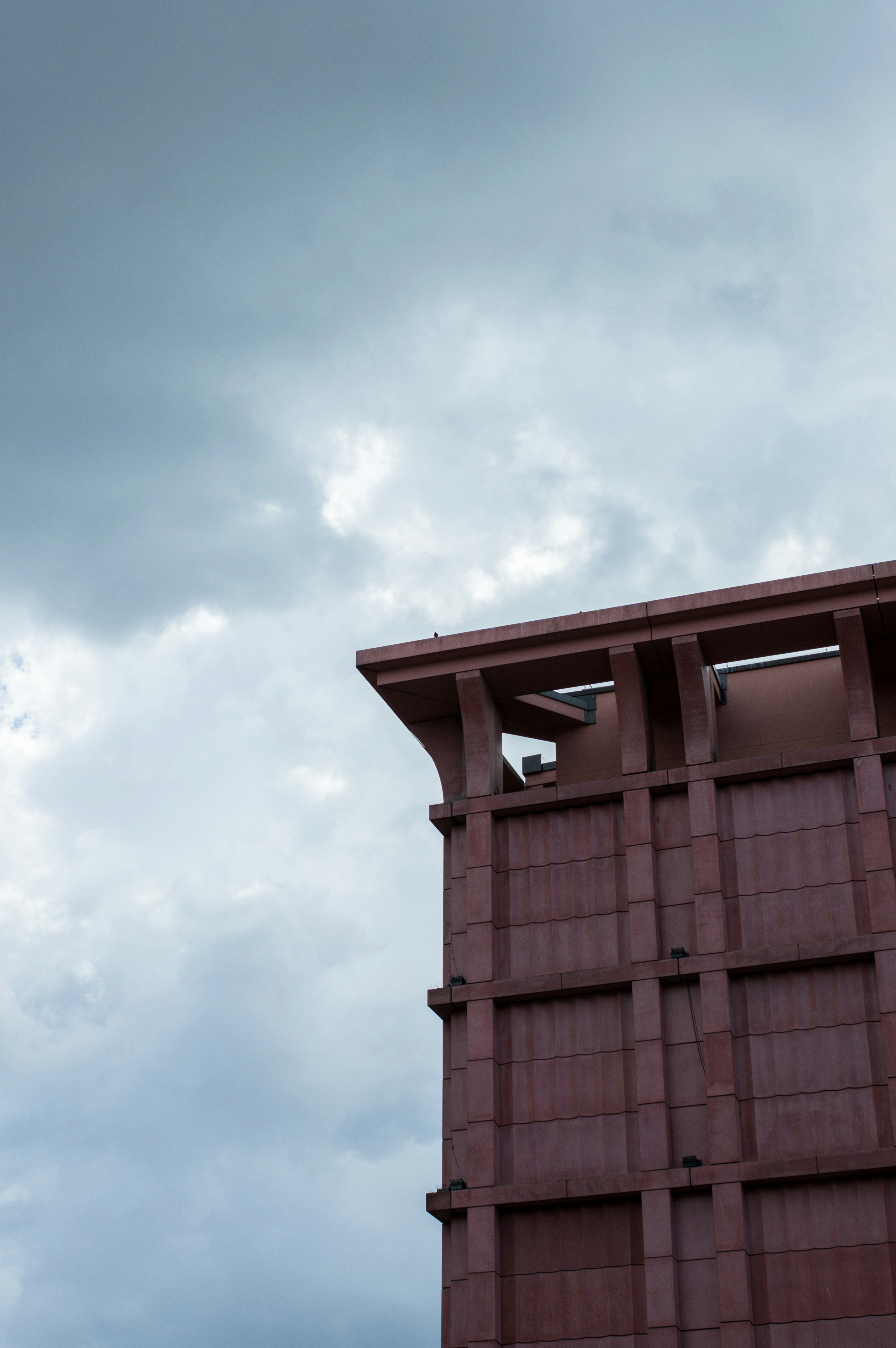 Un grand bâtiment avec un ciel nuageux