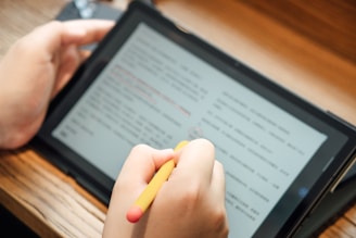 a person writing on a tablet