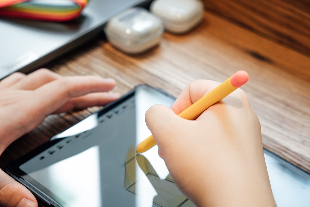 a person holding a yellow pencil