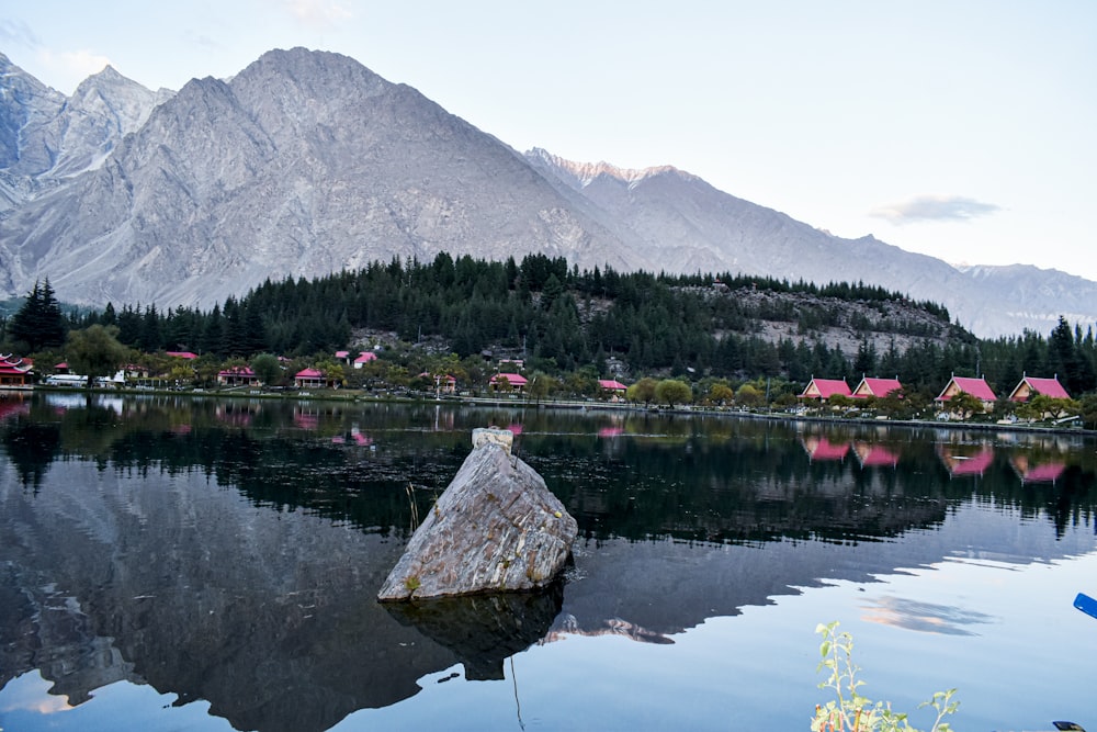 a body of water with a rock in it and a mountain in the background