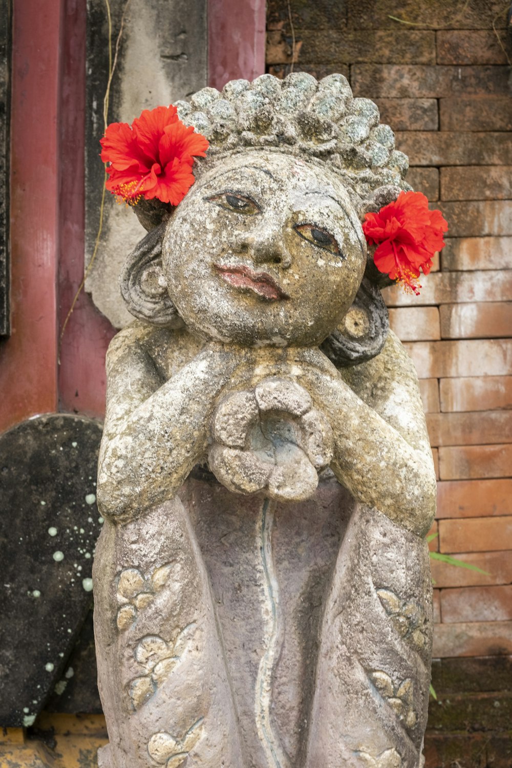 a statue of a person with a flower on the head