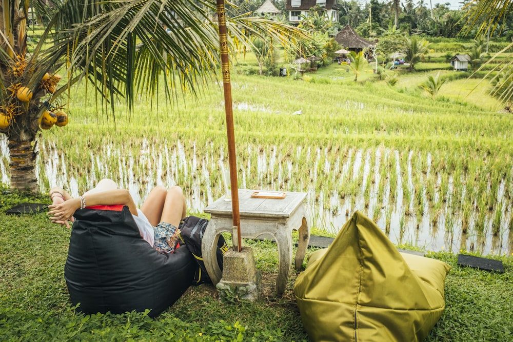 a person lying on a hammock in a grassy area