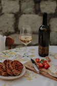 A warm, inviting table setting with sardines, herbs, and a glass of white wine.