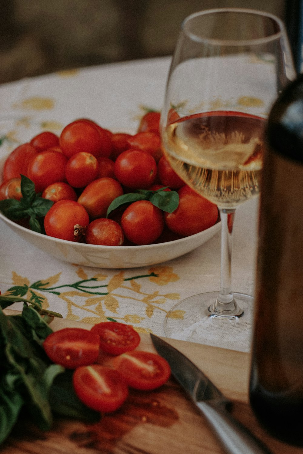 a bowl of tomatoes and a glass of wine