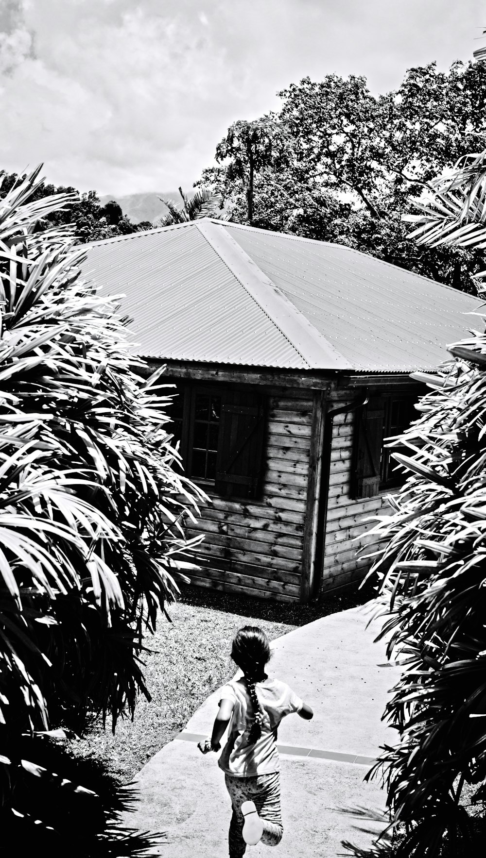 a child walking on a path by a house