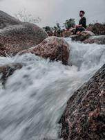 A peaceful meditation circle sitting on large stones near a calm forest stream.