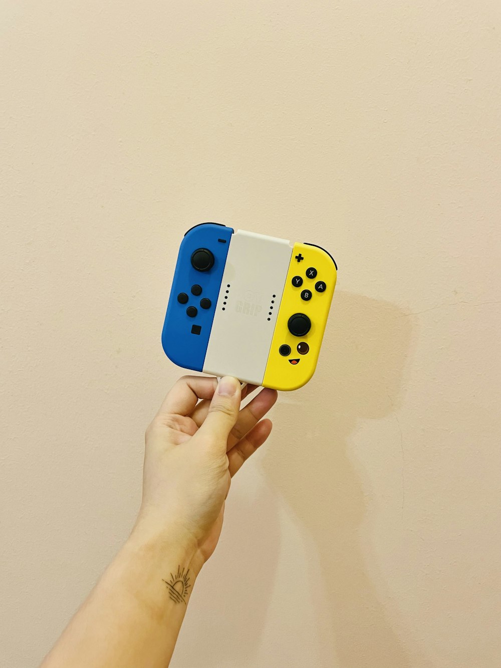 a hand holding a yellow and black game controller