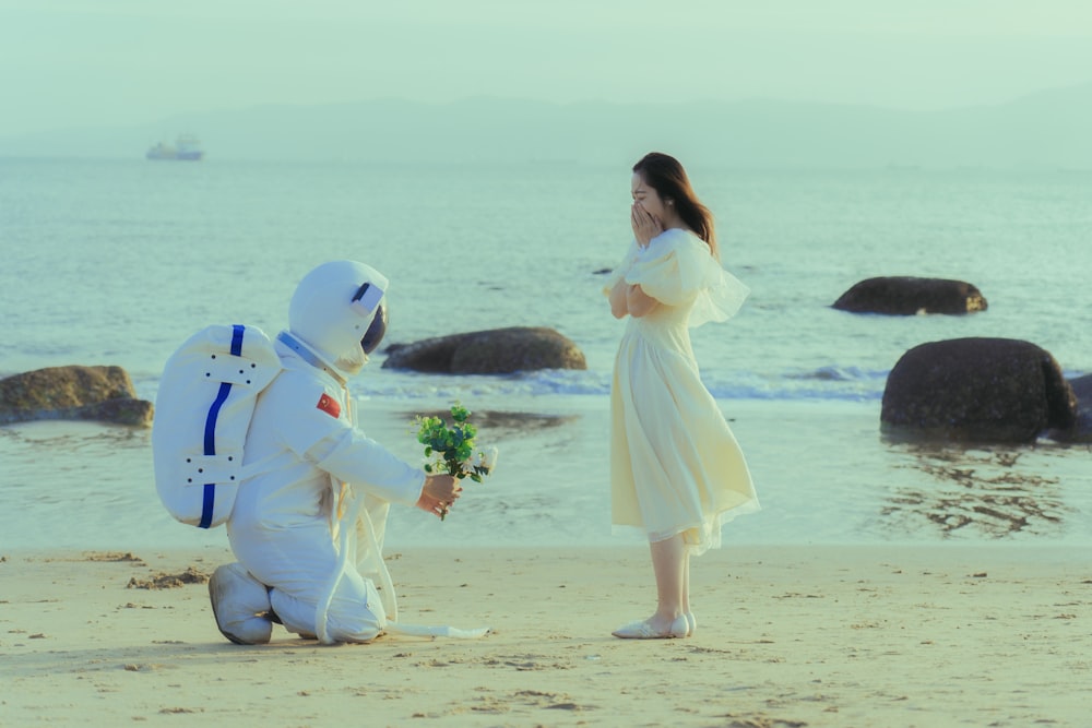 a person standing next to two people in clothing on a beach