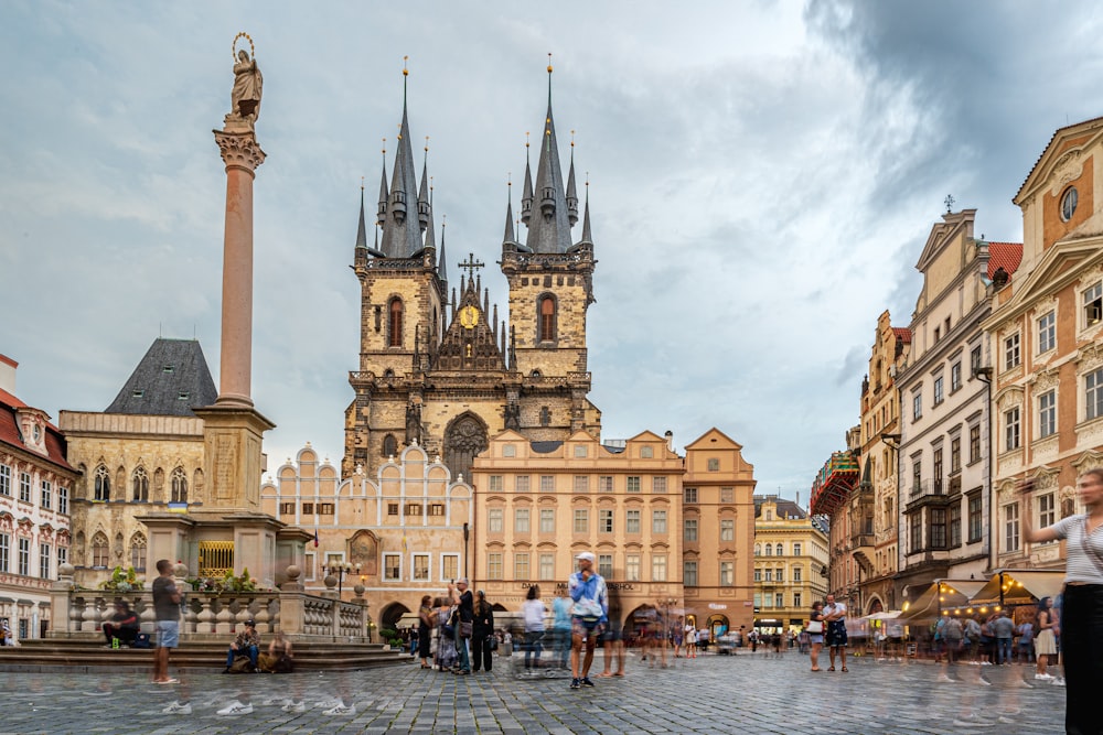 a group of people outside of a building with towers