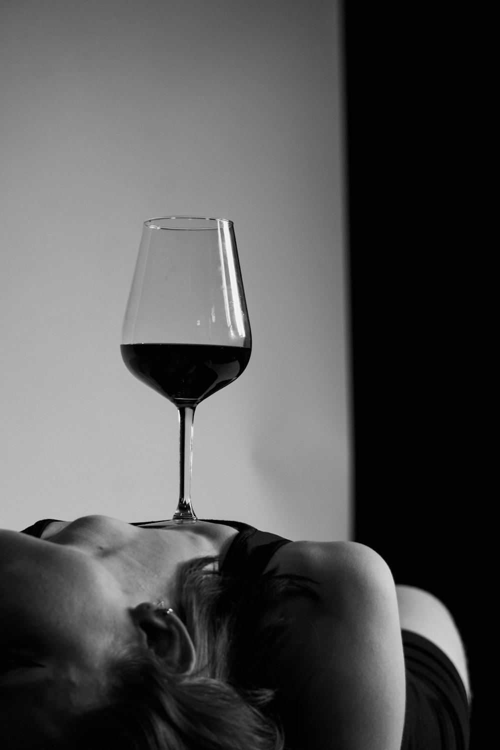 a woman sleeping next to a wine glass