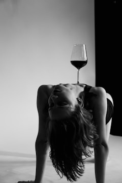 a person lying on the ground with a glass of wine on the head