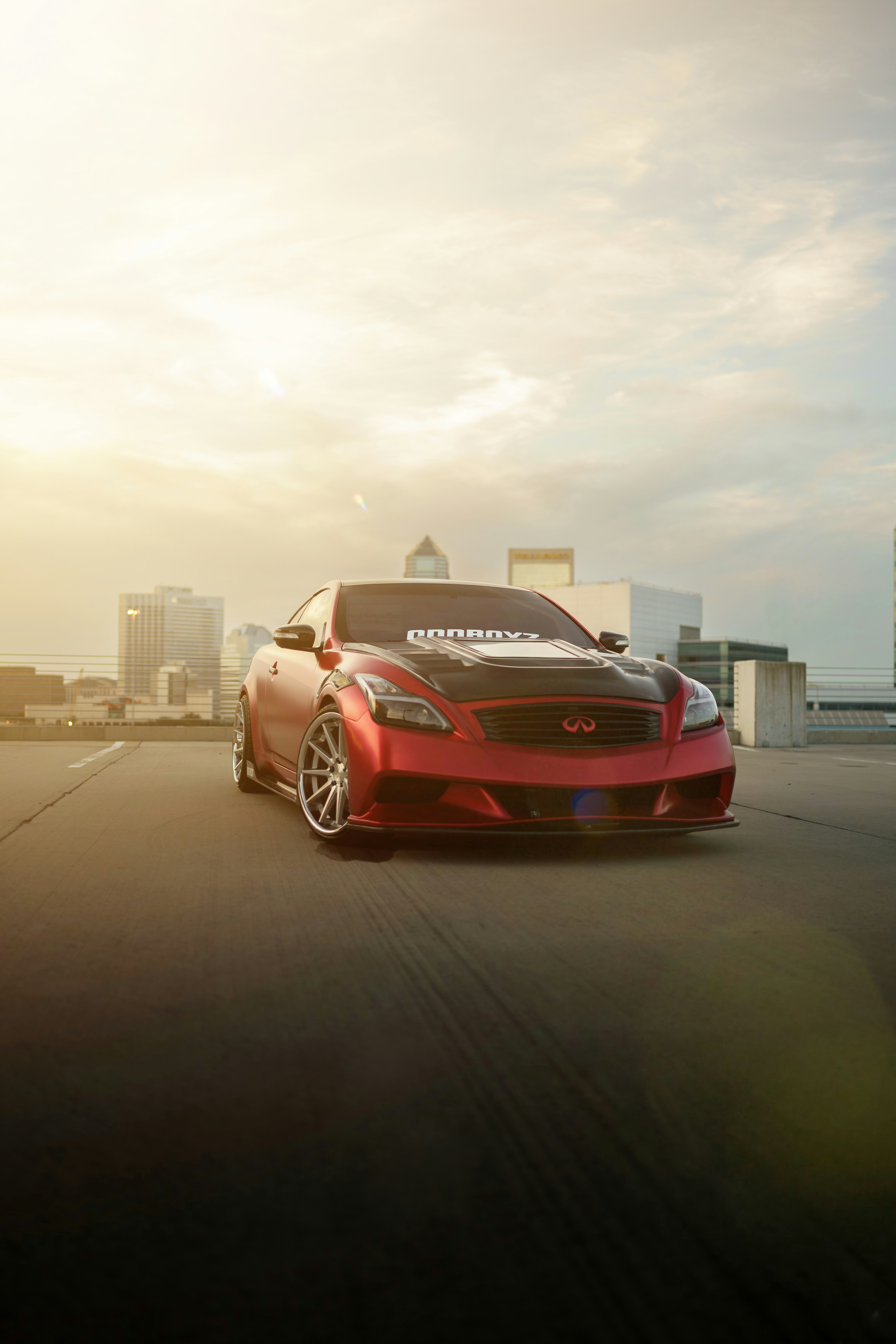 a red sports car parked on a road with buildings in the background