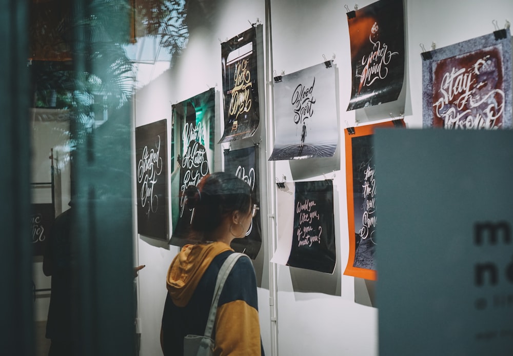 a person looking at posters on a wall