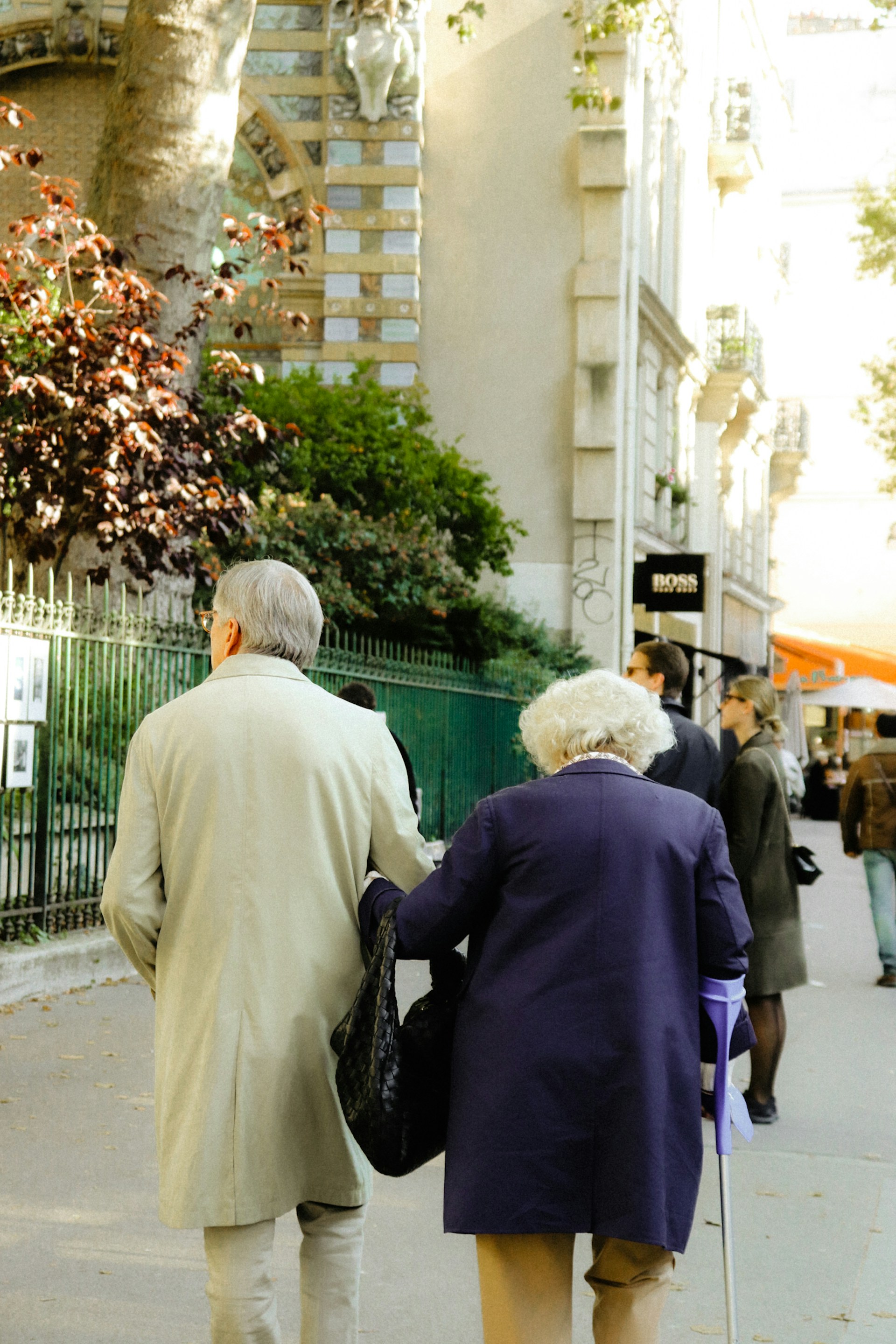 a couple of people walking down a sidewalk