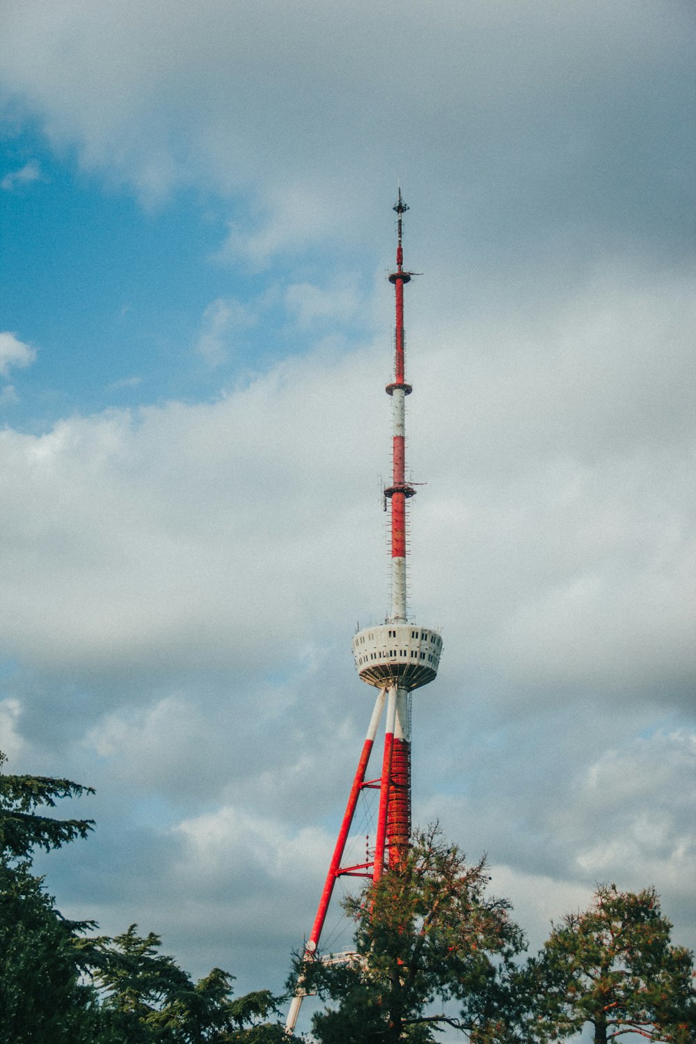 ein hoher Turm mit rot-weißer Spitze