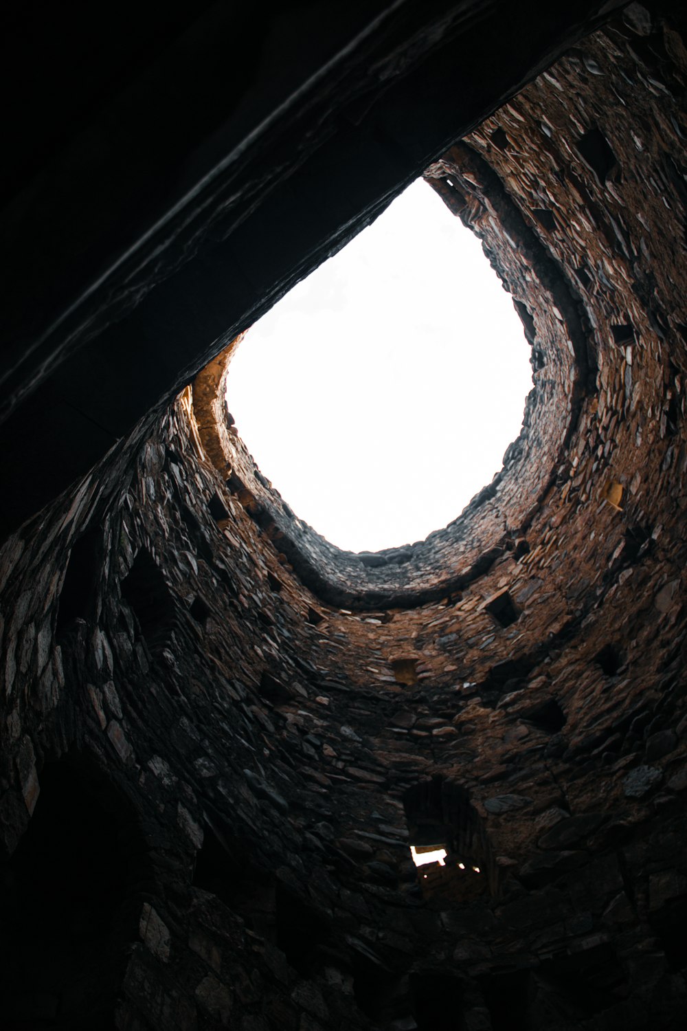 a stone tunnel with a light at the end