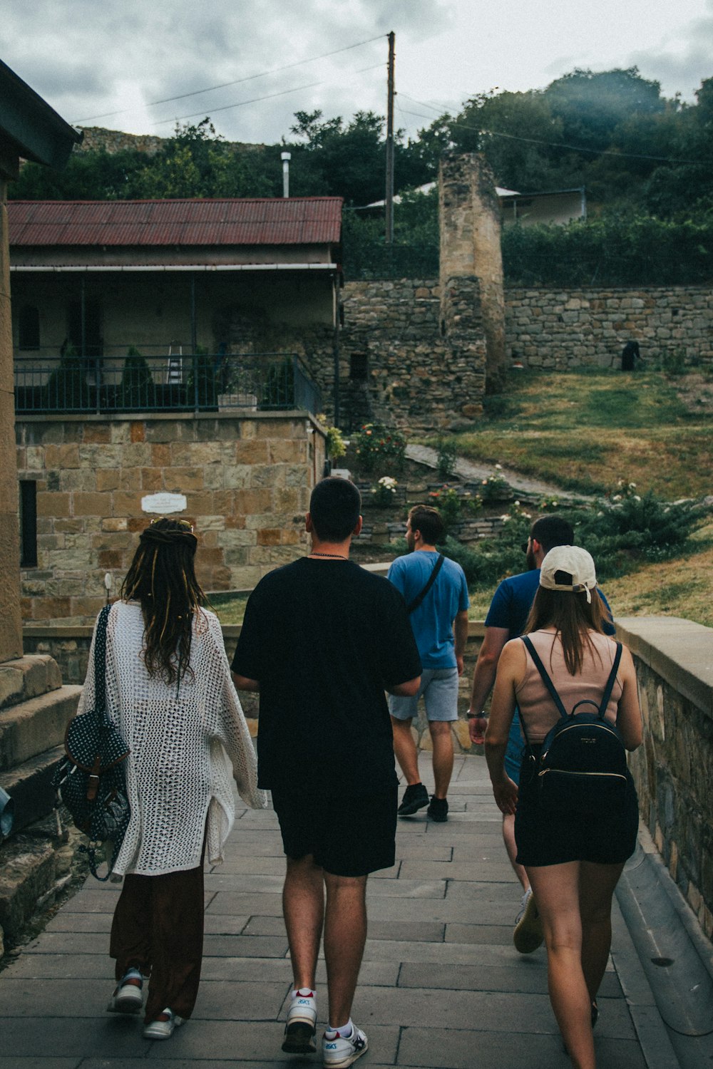 a group of people walking on a stone path