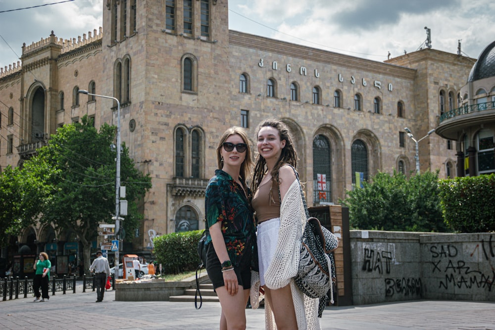 two women standing in front of a building