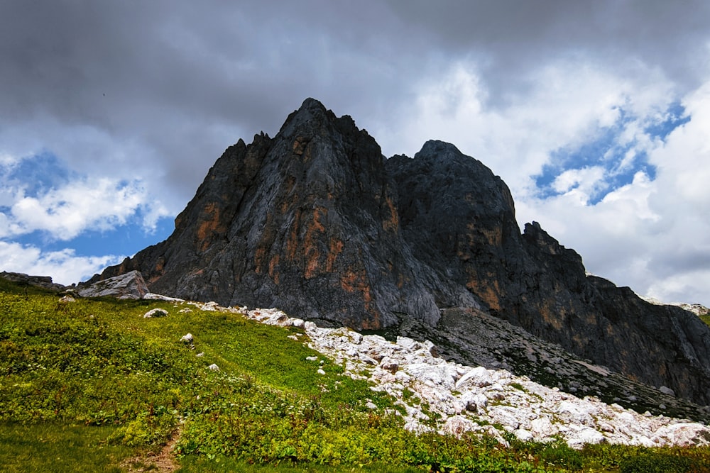 a rocky mountain with grass and rocks