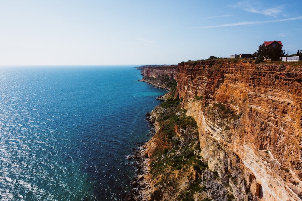 a cliff side with a body of water below