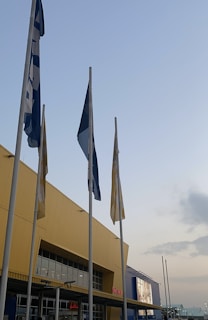 A formal government building entrance with flags and clear signage.