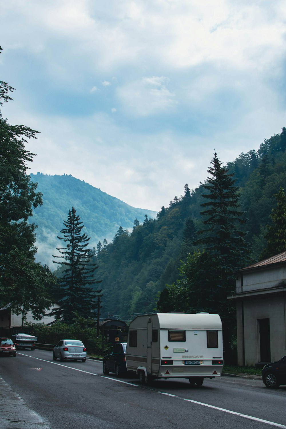 a white truck on a road with trees and mountains in the background