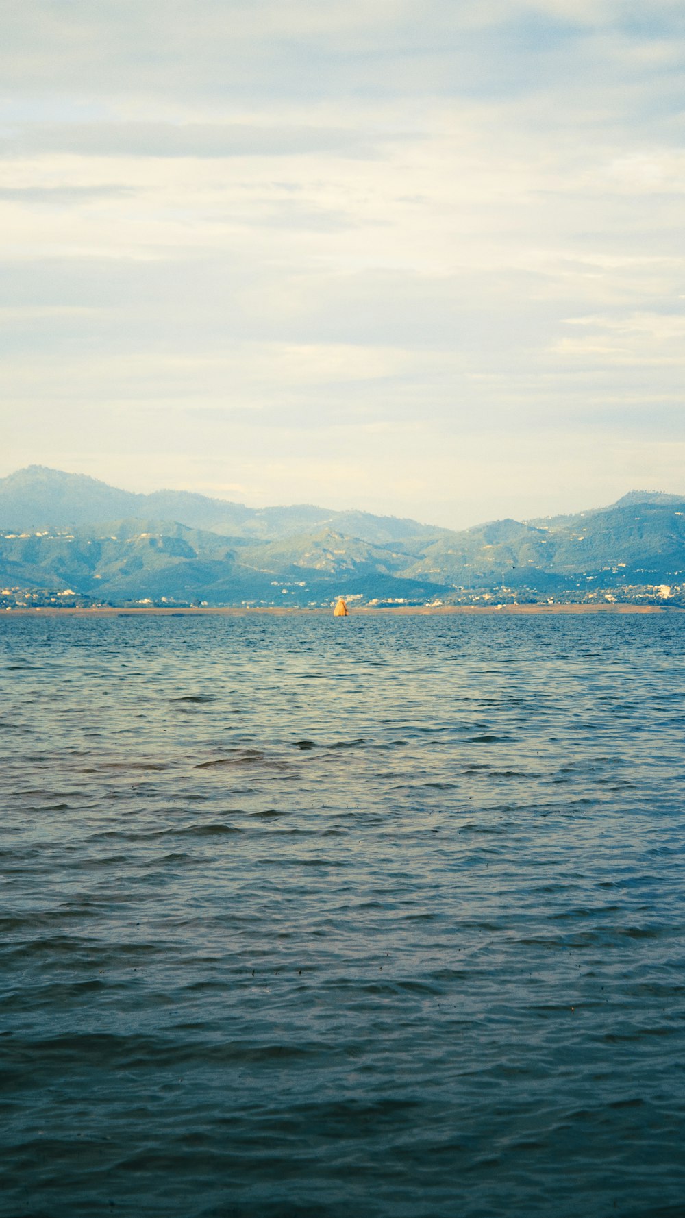 a body of water with mountains in the background