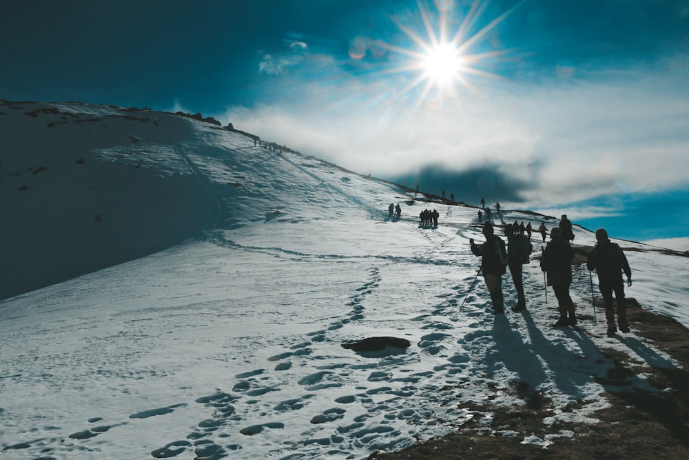 a group of people walking on a snowy hill