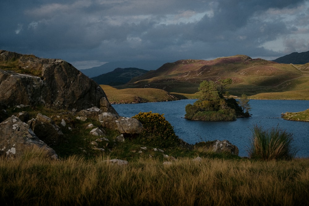 a body of water surrounded by rocks and grass