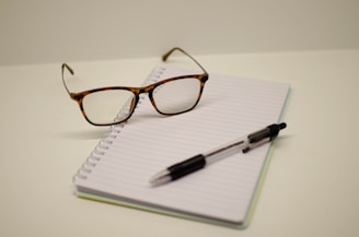 a pen and glasses on a notebook