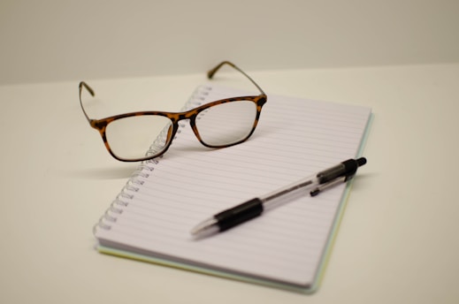 a pen and glasses on a notebook