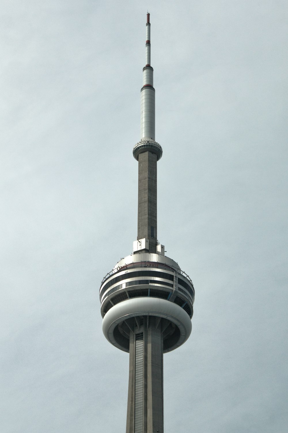 a tall tower with a circular top with CN Tower in the background