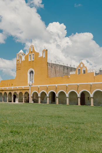 a large building with a grass field in front of it