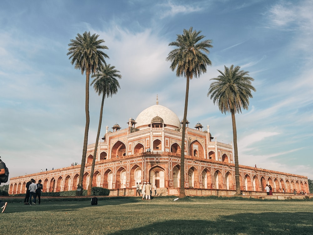 a large building with palm trees in front of it