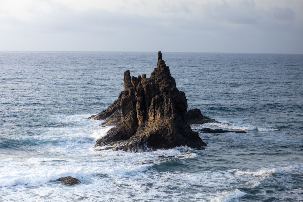 a large rock in the middle of the ocean