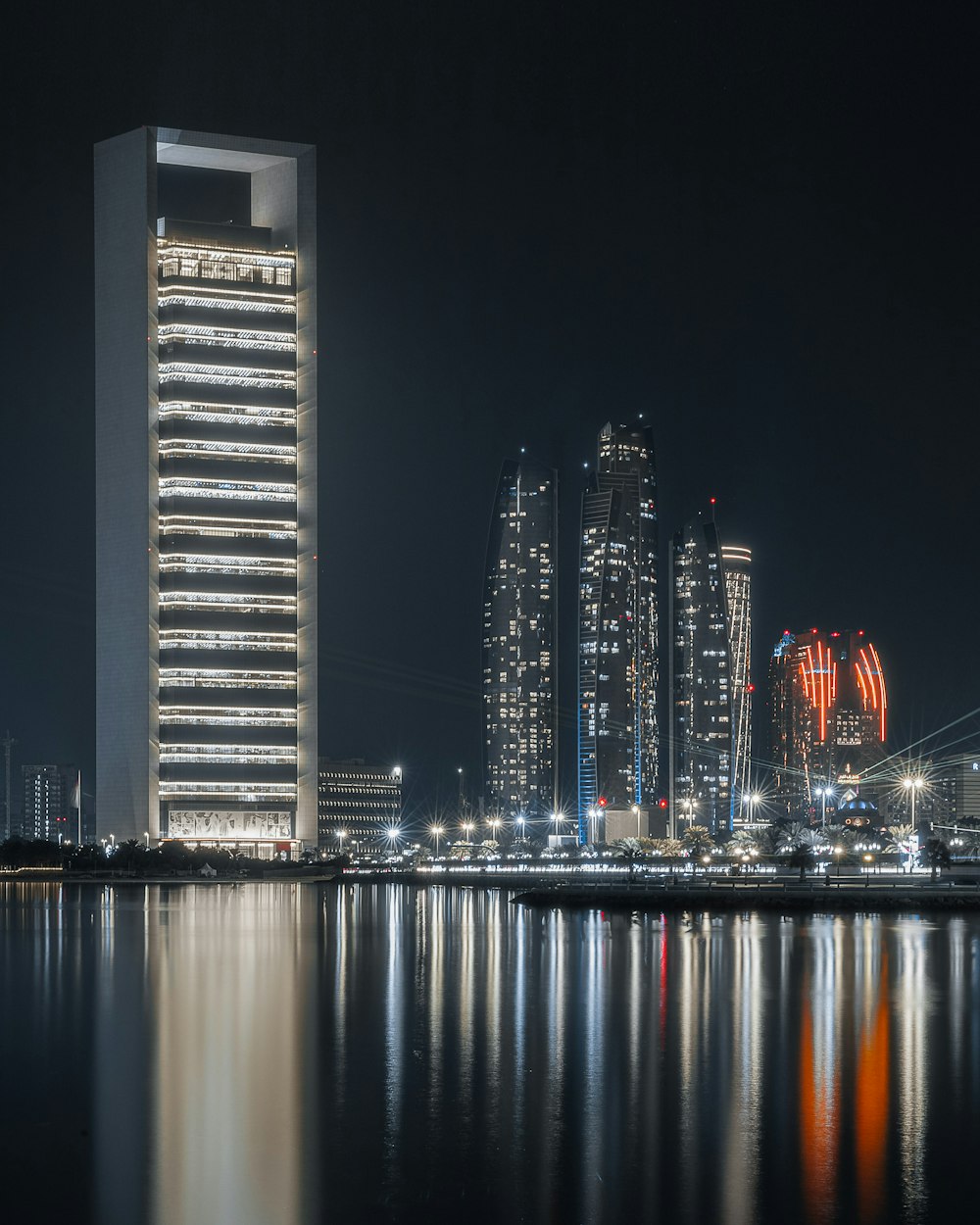 a couple of tall buildings by water