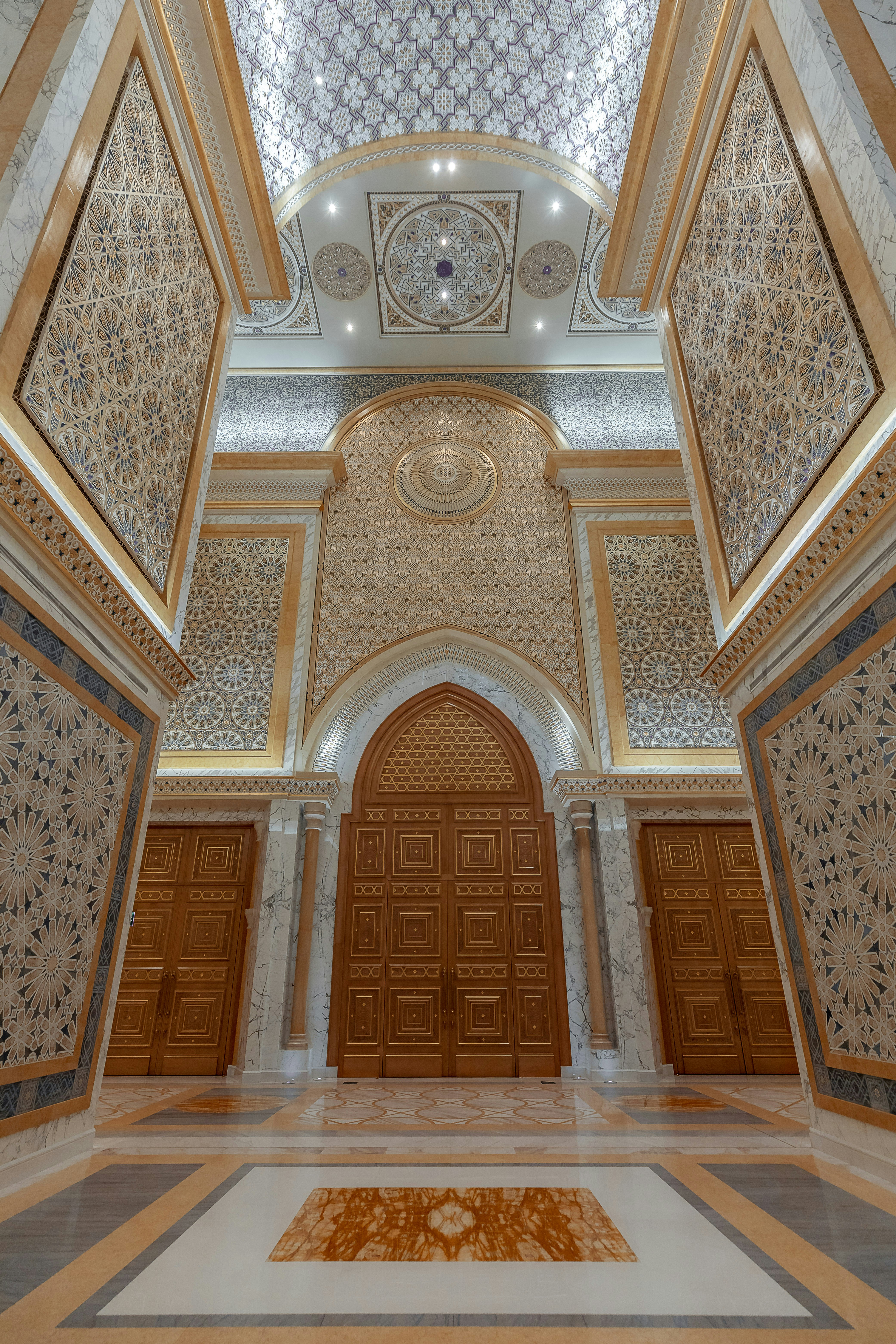 a large ornate room with a large door and a rug