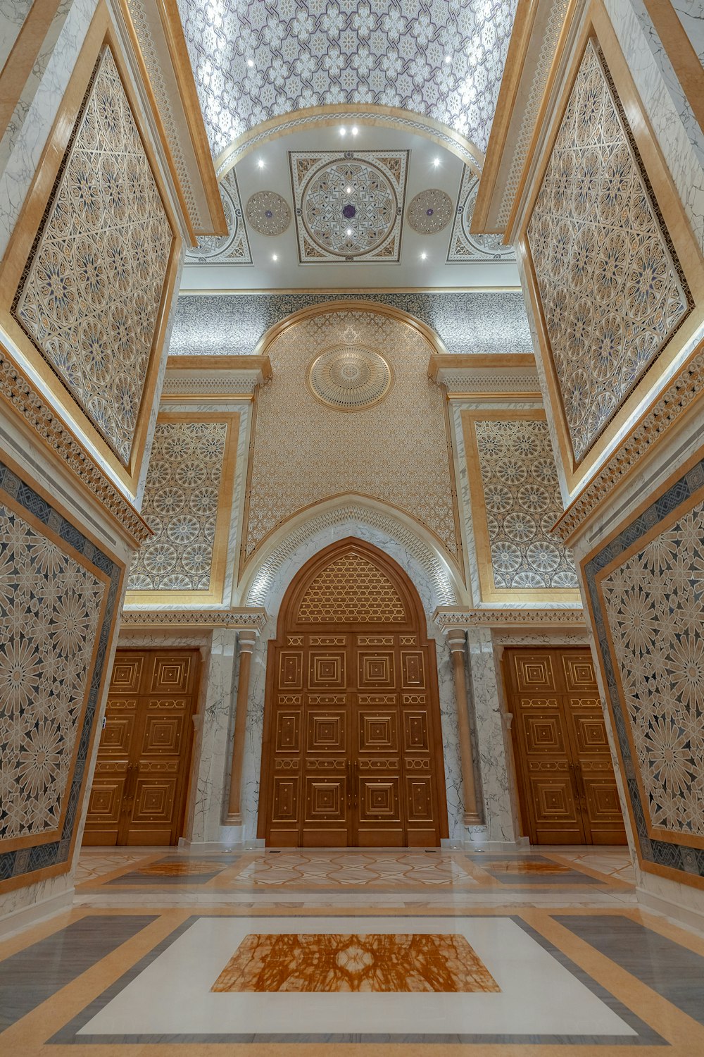 a large ornate room with a large door and a rug