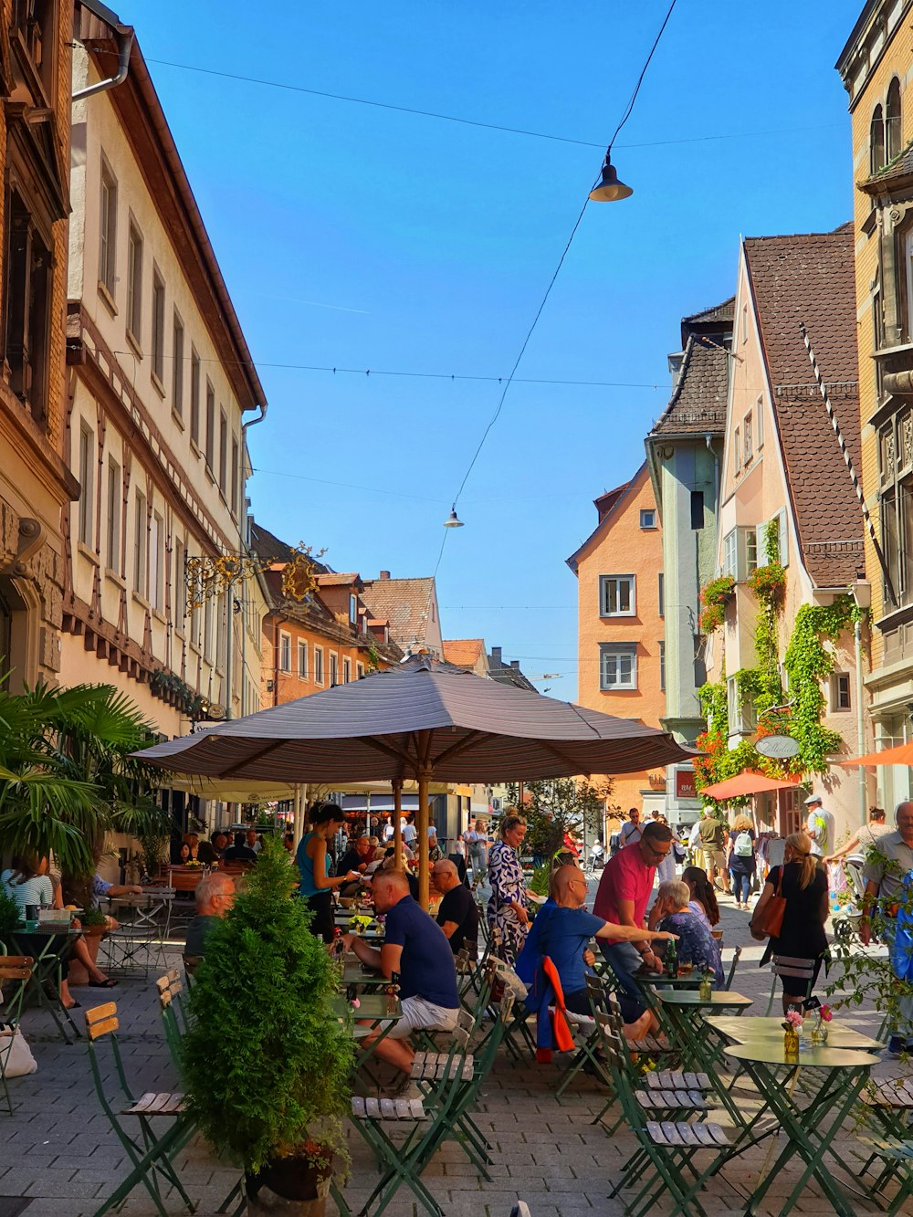 a group of people sitting at tables in a city