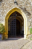 Close-up of a welcoming entrance gate with natural stone and wooden details in terracotta tones.