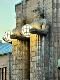 a statue of a person holding a light bulb